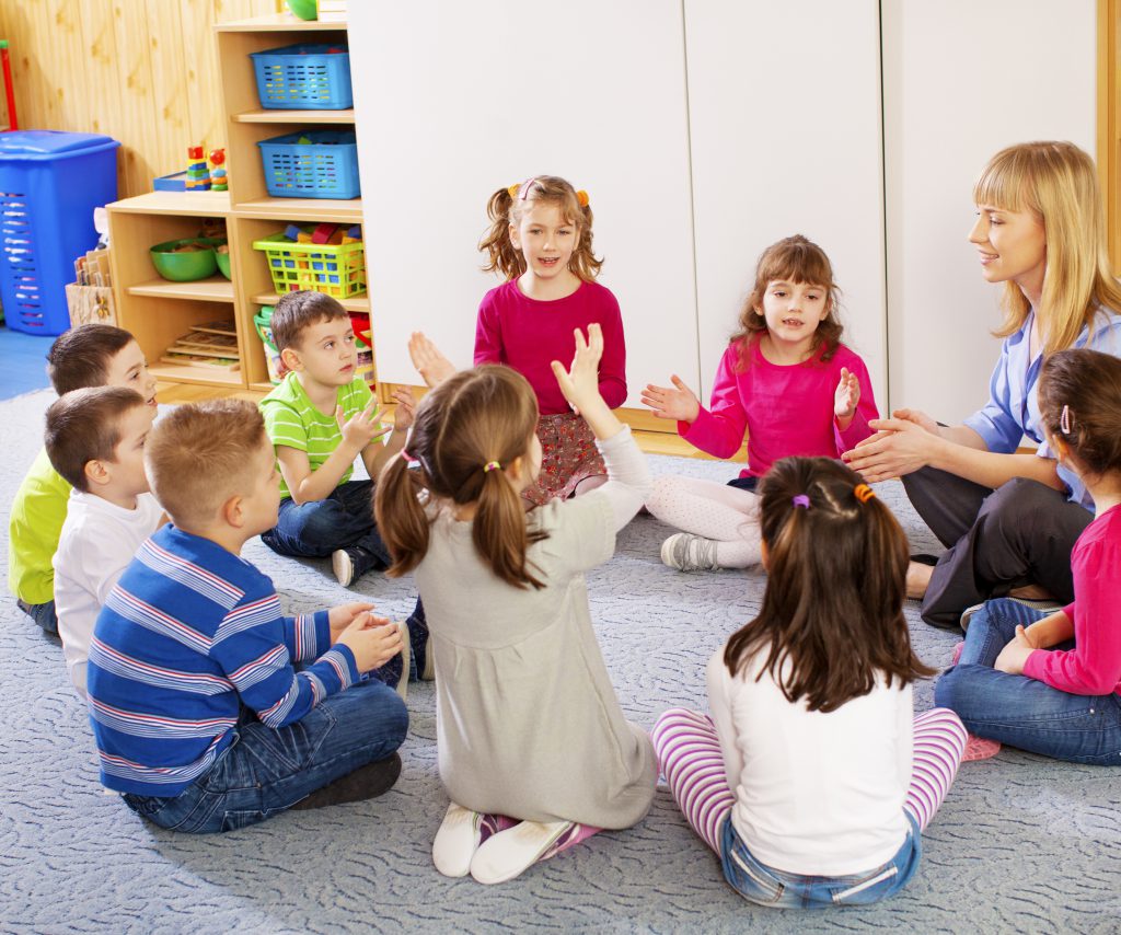 Therapist with the children singing in the best speech and language therapy clinic.